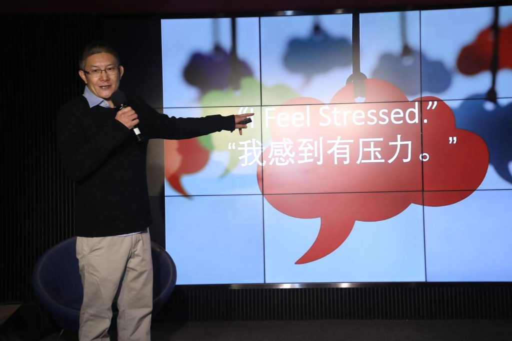 A photo of Chris Cheung presenting in front of a screen saying 'I am stressed'